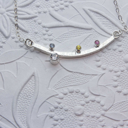 Sterling silver bar necklace featuring topaz, sapphires, grey spinal, sterling silver chain
