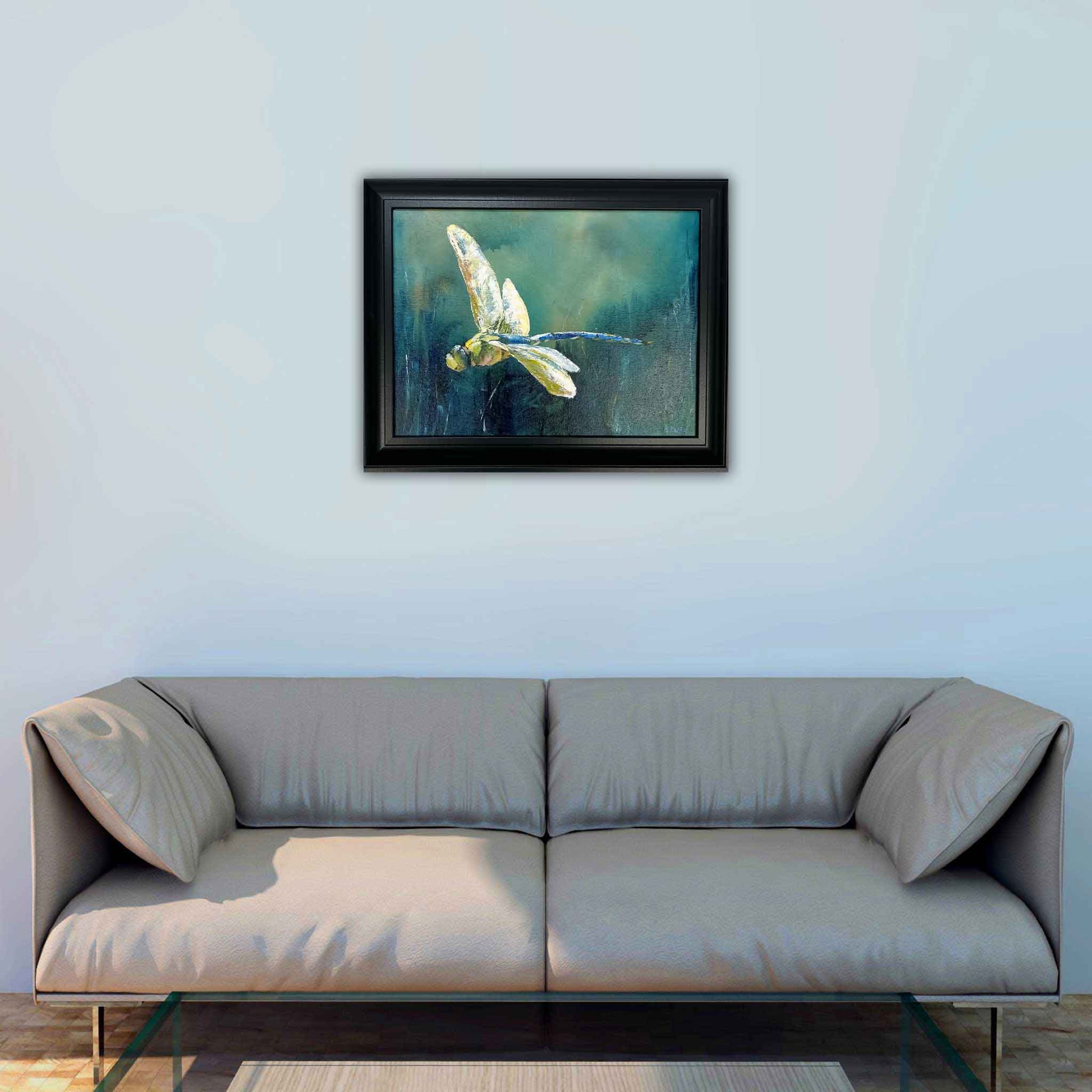 JRO In Flight - Dragonfly Swooping Down Painting by Artist Becky Owen. An original acrylic painting. Brilliant yellow dragonfly set against a blue and green background. Framed in a black wooden frame. 14" x 17".