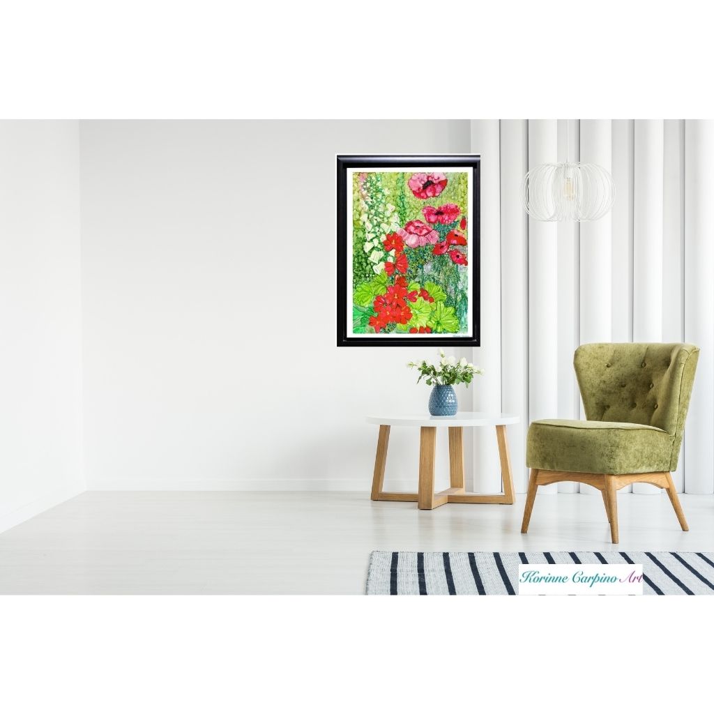 a black framed cottage garden poppy print with red and white flowers in a white room with a green chair and white table